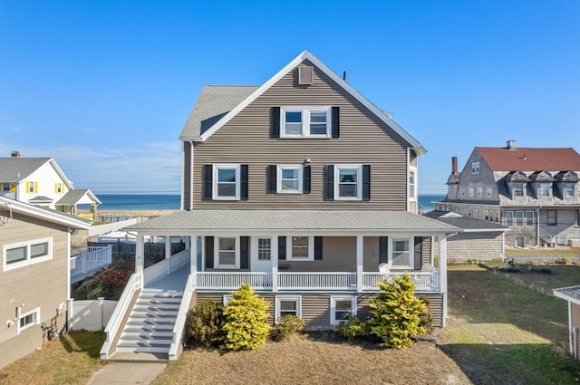 view of front of home with a porch and a water view