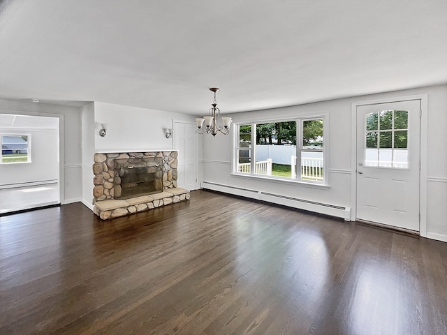 unfurnished living room featuring a baseboard heating unit, dark hardwood / wood-style flooring, a fireplace, and a notable chandelier