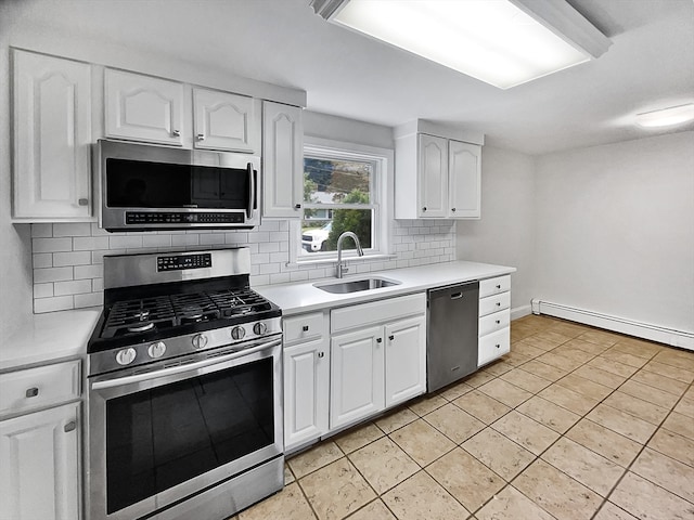 kitchen featuring white cabinetry, backsplash, stainless steel appliances, sink, and a baseboard heating unit