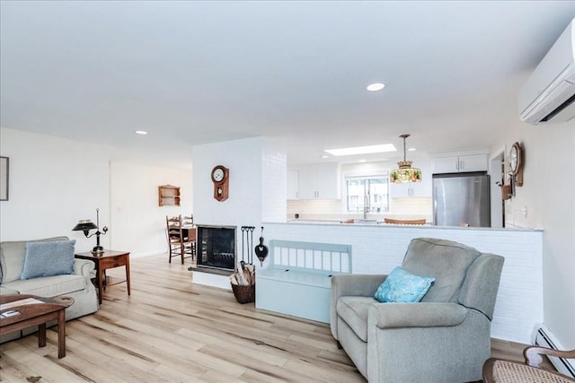 15 Trask Rd, Peabody, MA 01960 - living area with a wall mounted air conditioner, light wood-type flooring, recessed lighting, a fireplace, and baseboard heating