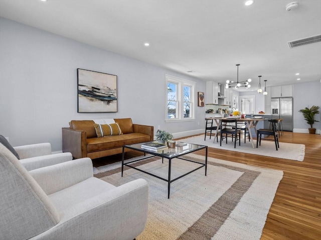 living room with hardwood / wood-style floors and a chandelier