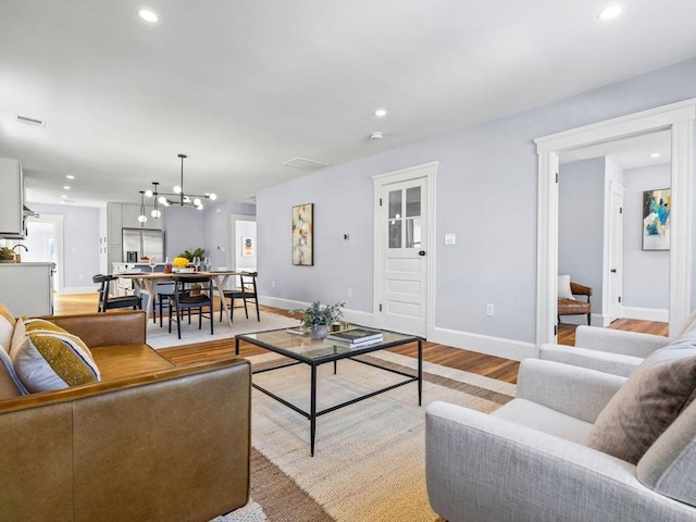 living room featuring light wood-type flooring and an inviting chandelier