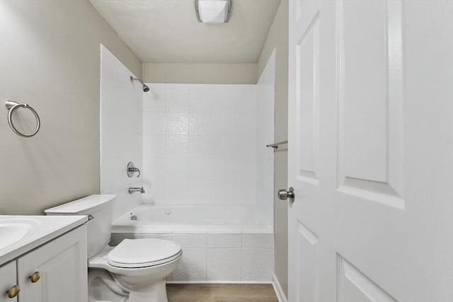 full bathroom featuring wood finished floors, toilet, tiled shower / bath combo, and vanity