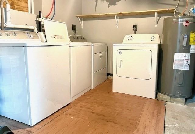 washroom featuring electric water heater and washing machine and clothes dryer