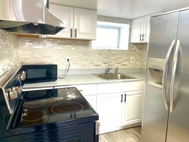 kitchen with black appliances, white cabinetry, decorative backsplash, sink, and ventilation hood