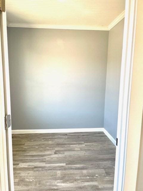 empty room featuring dark wood-type flooring and ornamental molding