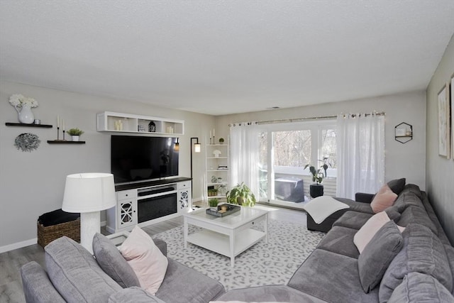 living area featuring baseboards and wood finished floors