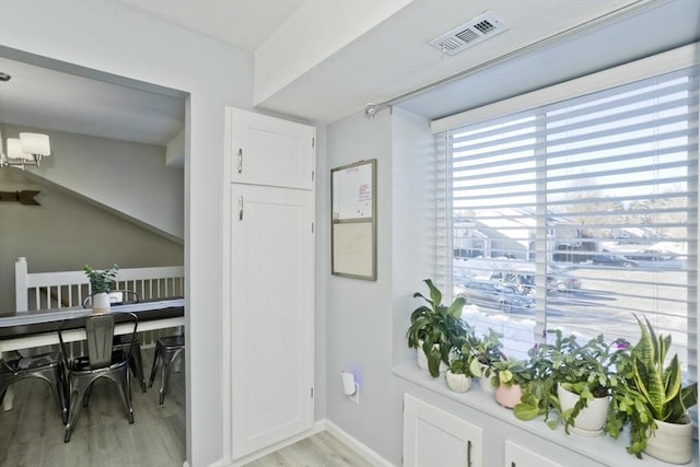 doorway to outside featuring light wood-type flooring, visible vents, and baseboards