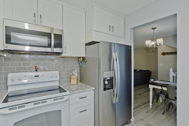 kitchen with tasteful backsplash, appliances with stainless steel finishes, and white cabinets