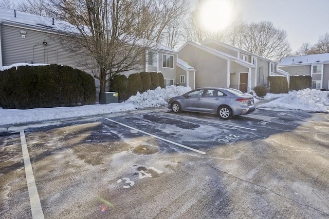 snow covered parking with uncovered parking and a residential view