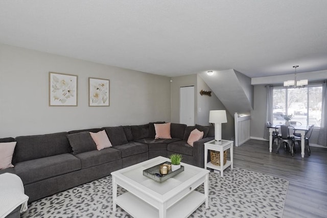 living area with a chandelier, baseboards, and wood finished floors