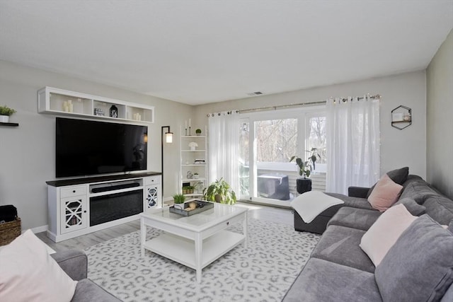 living area with visible vents and light wood-style flooring