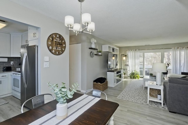 dining area featuring light wood-style flooring and a notable chandelier