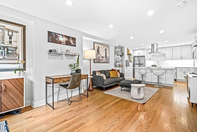 living room featuring recessed lighting, light wood-type flooring, and baseboards