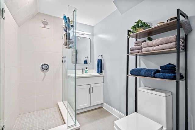 bathroom with vanity, a shower stall, toilet, and baseboards