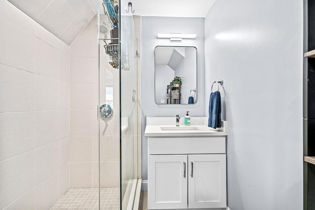 full bath with vanity, lofted ceiling, and a tile shower