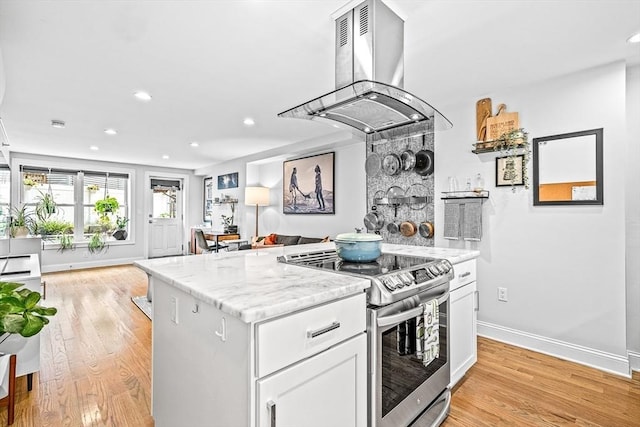 kitchen featuring ventilation hood, light wood finished floors, electric range, white cabinets, and open floor plan