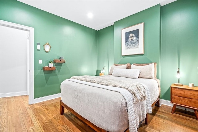 bedroom with wood finished floors and baseboards