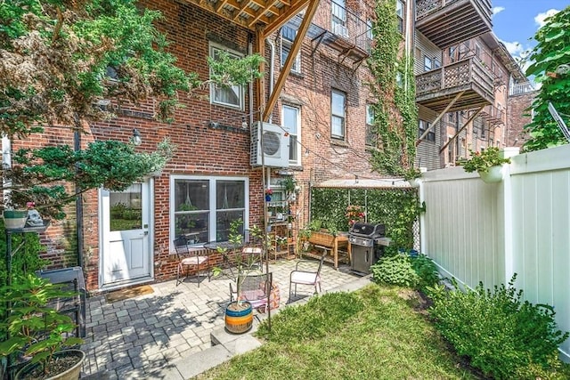 back of property featuring brick siding, ac unit, a patio area, and fence