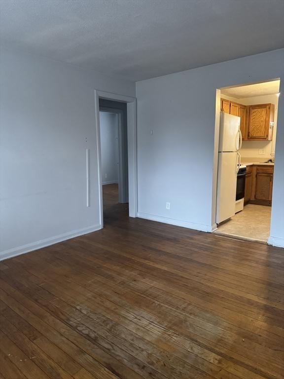 unfurnished room with dark wood-type flooring