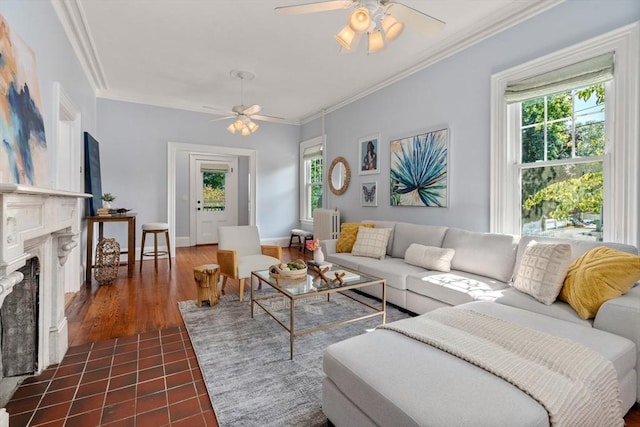 living area with a ceiling fan, a fireplace, ornamental molding, and a wealth of natural light