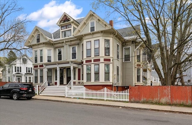 victorian house featuring a fenced front yard