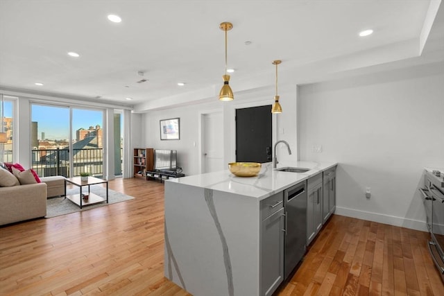 kitchen with kitchen peninsula, dishwasher, light stone countertops, pendant lighting, and sink