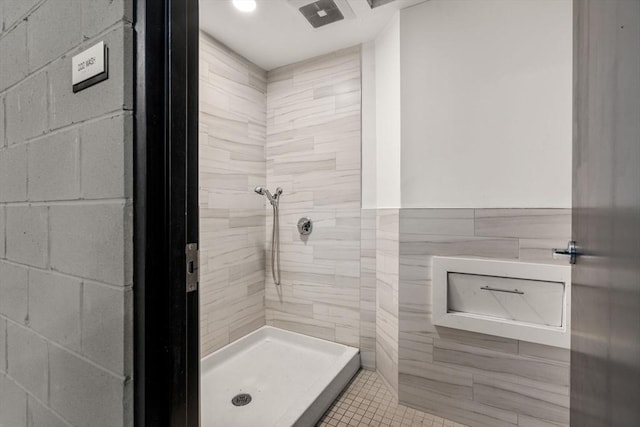 bathroom featuring walk in shower, tile walls, and tile patterned floors