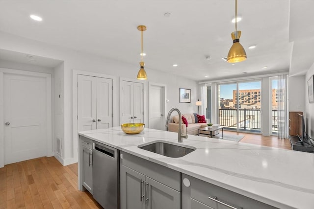 kitchen featuring decorative light fixtures, dishwasher, gray cabinets, sink, and light stone counters