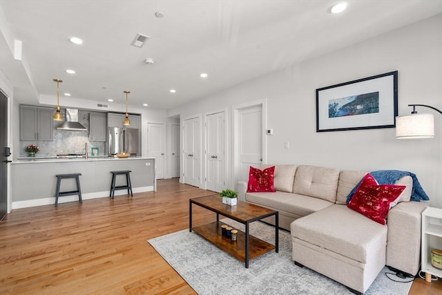 living room featuring sink and light wood-type flooring