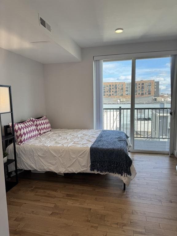 bedroom with access to exterior and hardwood / wood-style floors