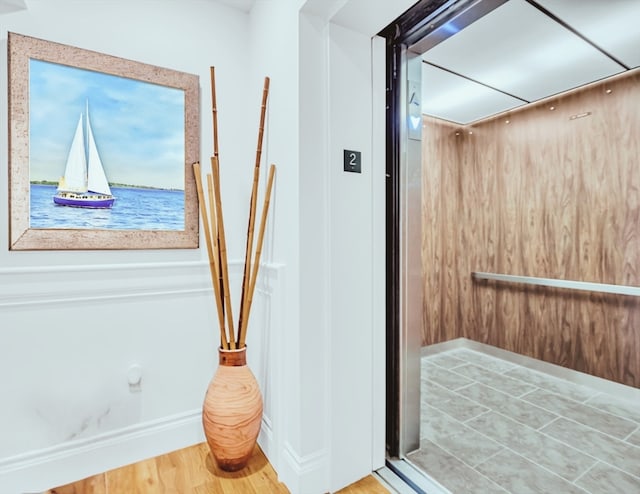 bathroom with hardwood / wood-style floors and elevator