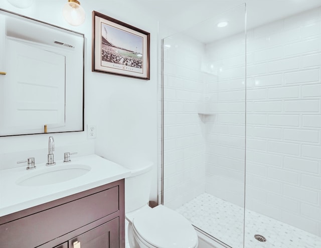 bathroom with vanity, a tile shower, and toilet