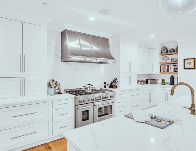 56 Belmont St Unit 3, Boston, MA 02129 - kitchen featuring double oven range, wall chimney exhaust hood, open shelves, decorative backsplash, and white cabinets