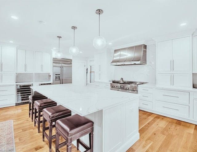 56 Belmont St Unit 3, Boston, MA 02129 - kitchen with beverage cooler, wall chimney range hood, premium appliances, a center island, and recessed lighting