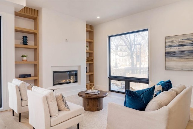 living room featuring built in shelves and light wood-type flooring