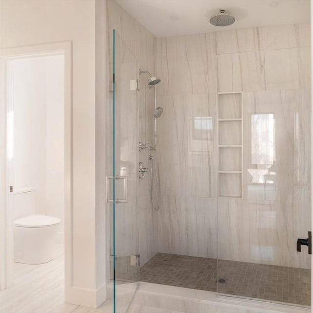 bathroom with toilet and a shower with shower door