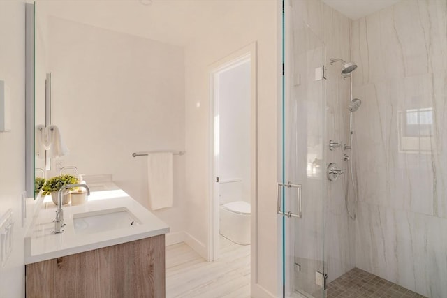 bathroom featuring vanity, toilet, and a shower with shower door