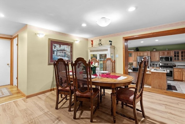 dining space with light hardwood / wood-style flooring and sink