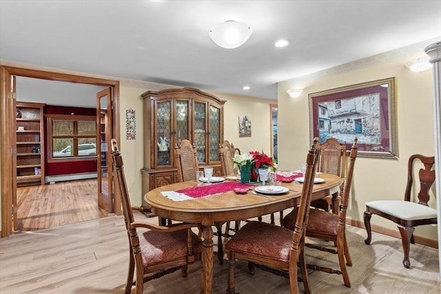 dining area with light hardwood / wood-style flooring and a baseboard heating unit