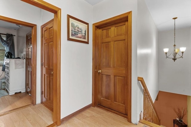 hall featuring a notable chandelier and light hardwood / wood-style floors