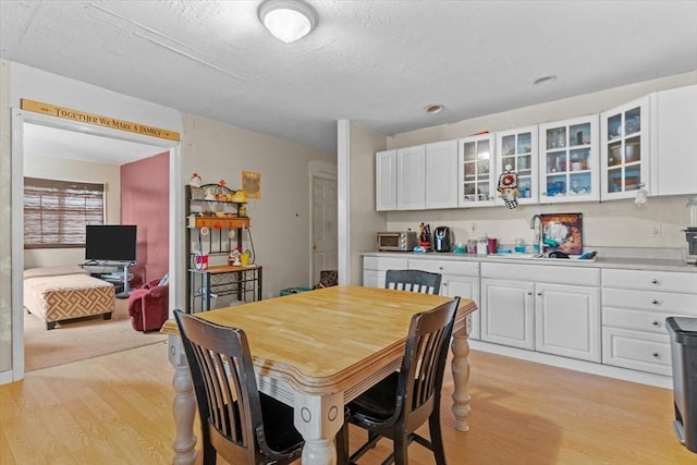 dining space with sink and light hardwood / wood-style floors