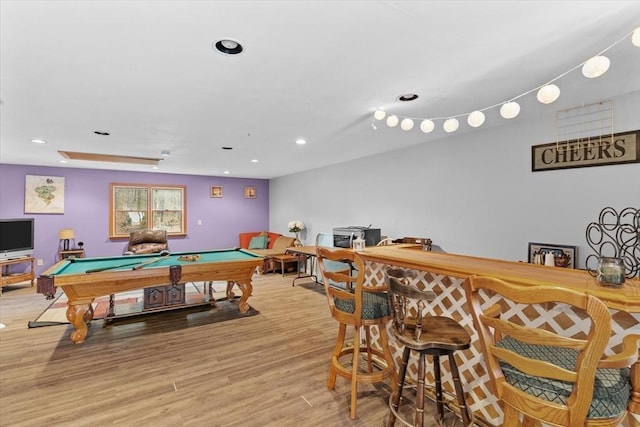 game room with bar area, pool table, and light hardwood / wood-style floors