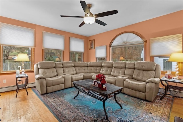 living room with ceiling fan, a baseboard radiator, and wood-type flooring