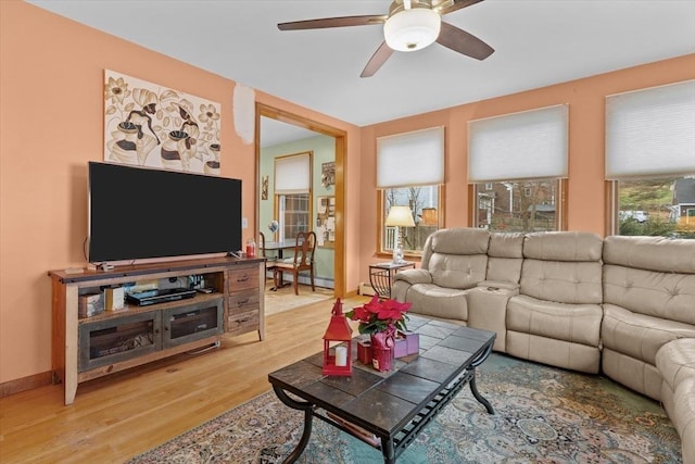 living room featuring wood-type flooring, a baseboard radiator, and ceiling fan