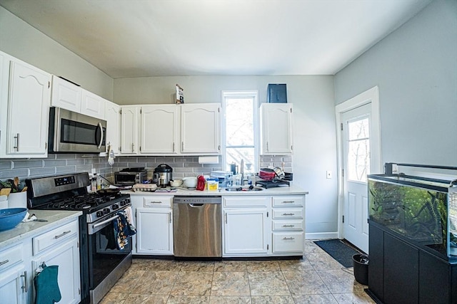 38 Highland Park Ave, Boston, MA 02119 - kitchen featuring backsplash, white cabinets, light countertops, and stainless steel appliances