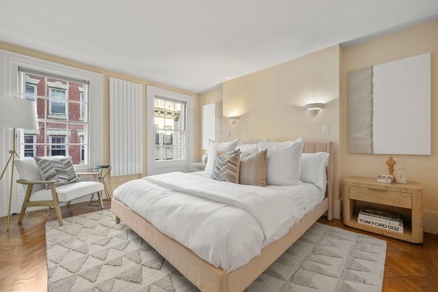 bedroom with light parquet floors and multiple windows