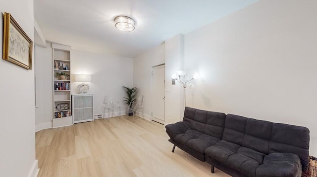 living area with baseboards and wood finished floors