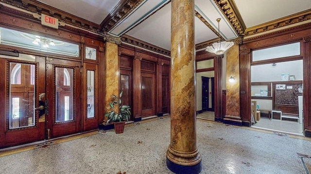 foyer featuring a healthy amount of sunlight, crown molding, and ornate columns