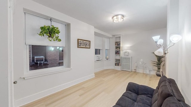 living area with baseboards and wood finished floors